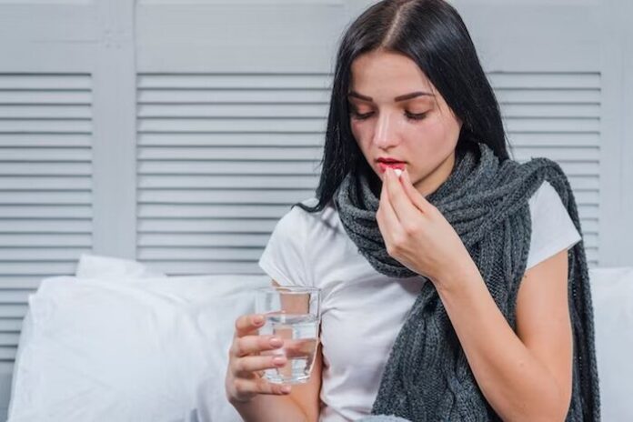 Pain Management. A woman taking pills to overcome pain