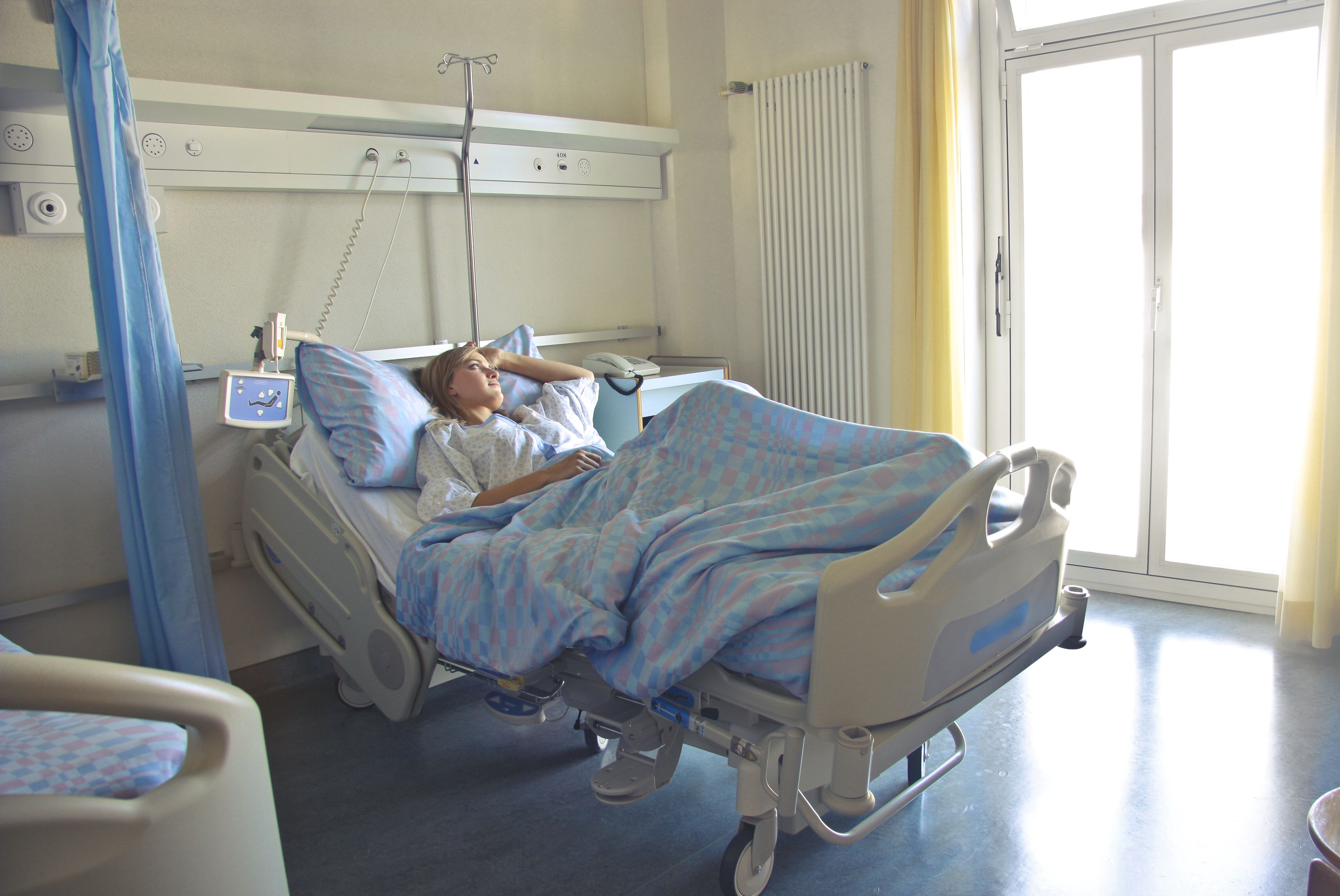 Patient resting in a hospital bed during the early recovery period after surgery